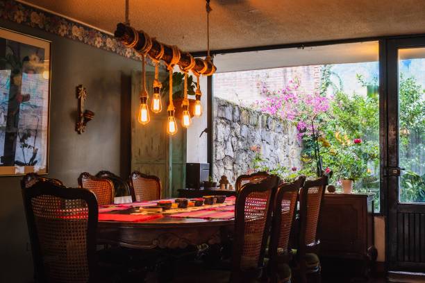 istock Rustic chandelier made of bulbs and ropes over a dining table in a vintage kitchen 1438909237