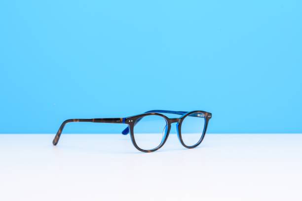 istock Pair of glasses on a white surface with a blue background 1438909530