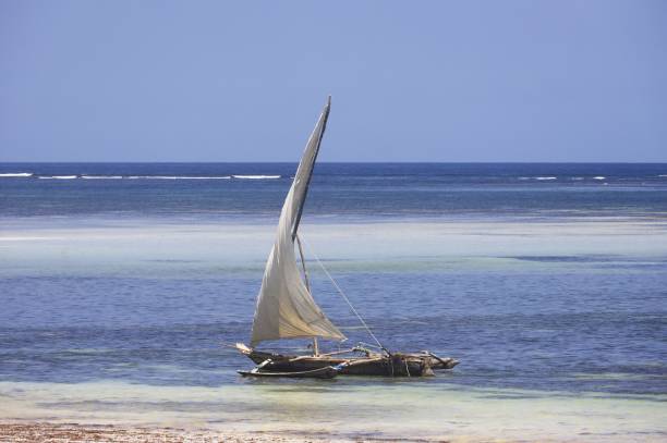 Chale Island, Kenya - March 12th, 2013: Fishermen sit in their traditional Dhows. These Sailing vessels are used in the Indian Ocean Region.