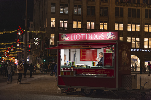 Amsterdam, Netherlands – March 05, 2019: fast food kiosk in a city square in Amsterdam at night