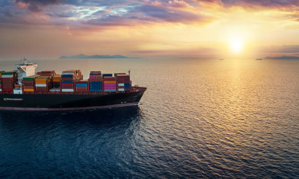 istock A cargo container ship sails over calm ocean into a golden sunset 1438915510