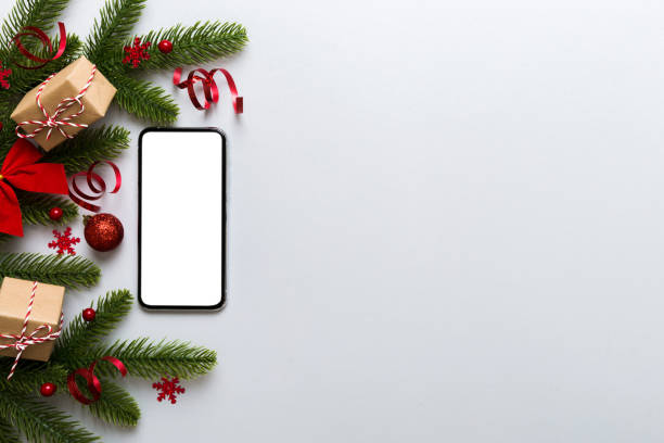 istock Digital phone mock up with rustic Christmas decorations for app presentation top view with empty space for you design. Christmas online shopping concept. Tablet with copy space on colored background 1438915657
