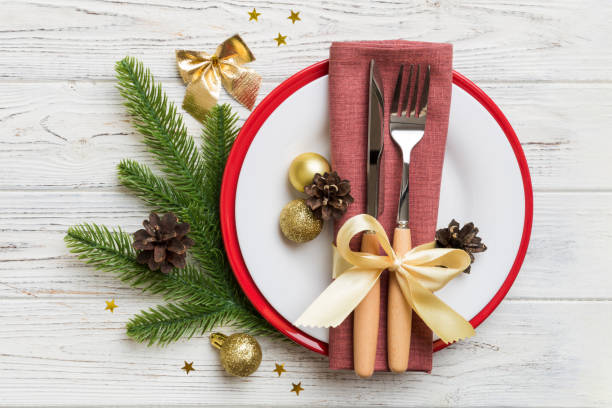 istock Christmas table place setting with christmas decor and plates, kine, fork and spoon. Christmas holiday background. Top view with copy space 1438915755