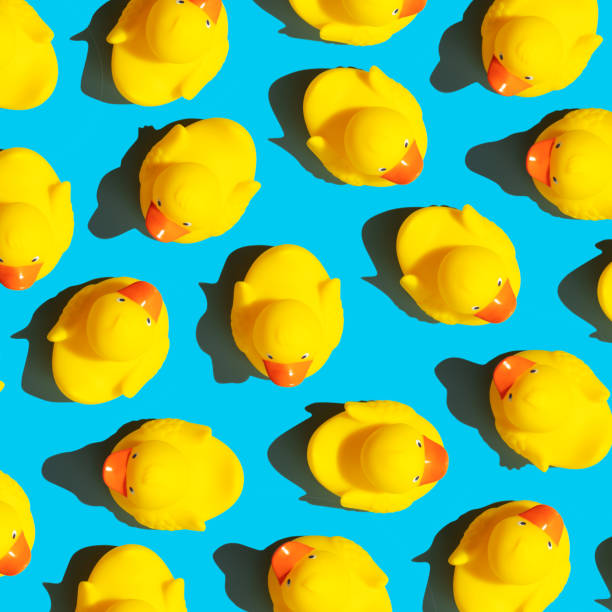 istock Collection of yellow rubber ducks on a blue background 1438915923