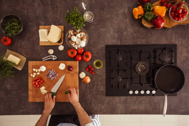 istock Man chopping up vegetables for a dish he is preparing 1438916297