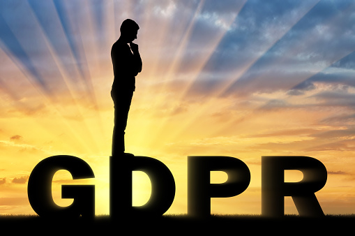 Silhouette pensive man standing on the word GDPR. Conceptual image about the law GDPR