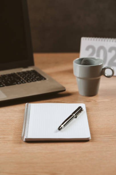 istock Blank notebook with a pen, a calendar, a notebook and a hot coffee - concept, goals and action plan, new year 1438918475