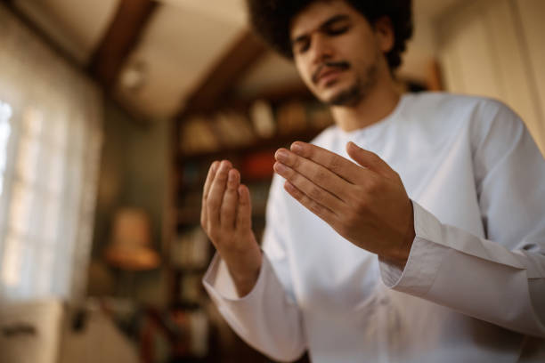 istock Close up of Middle Eastern man with hands in prayer pose at home. 1438923690