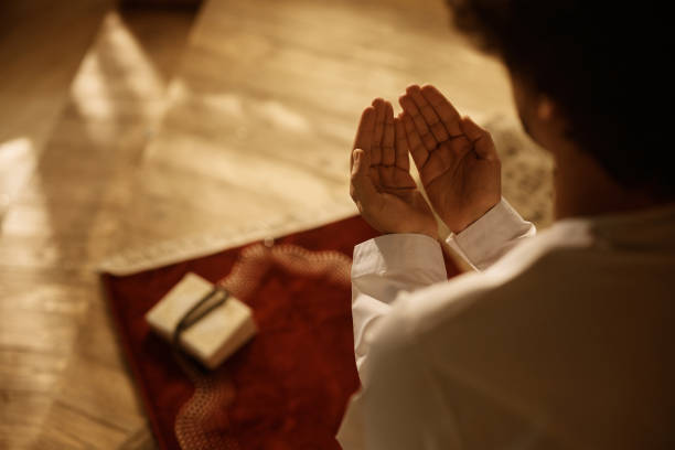 istock Close up of Middle Eastern man praying at home. 1438923833