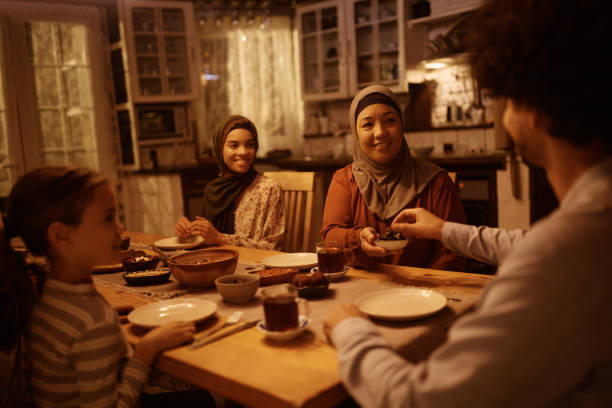 istock Happy extended Muslim family having dinner at dining table. 1438924067