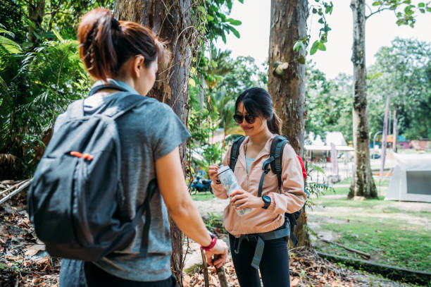 istock Two Asian female hiker with backpack taking a break and relaxing at the camp site 1438924279