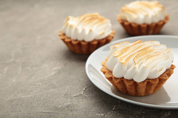 istock Appetizing lemon cupcakes with white cream on grey background. Holiday, surprise, birthday, Valentine's Day. 1438929756