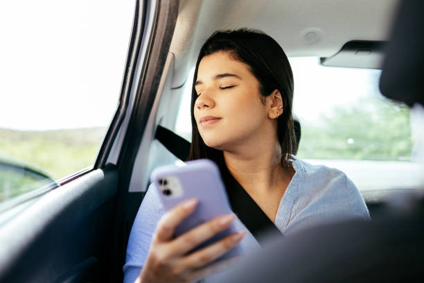 istock Businesswoman using smartphone in the car 1438930569