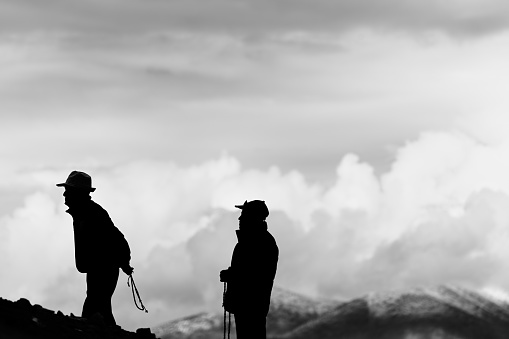 Leh, India, August 20th, 2022: Silhouettes of two men on the mountains of the Ladakh region