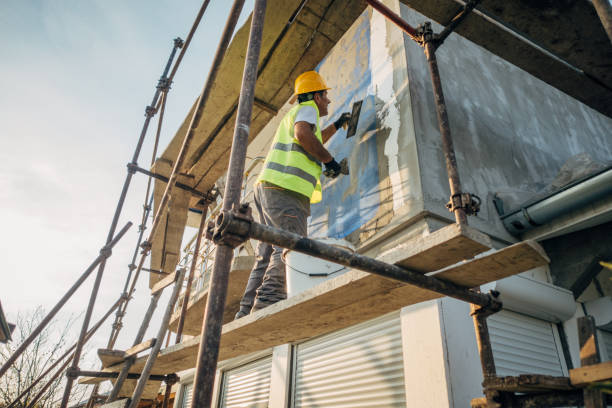 a construction worker builds the facade of a building - plaster plasterer wall repairing imagens e fotografias de stock