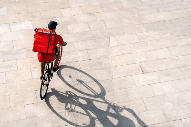 delivery man riding bike - bicycle messenger imagens e fotografias de stock