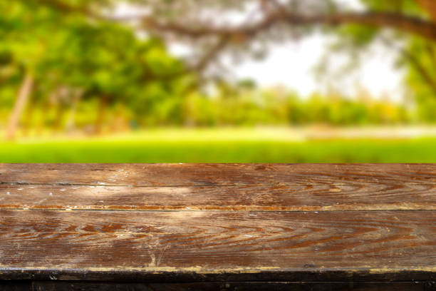 istock Empty wood plank table top with blur park green nature background bokeh light, Mock up for display or montage of product,Banner or header for advertise on social media and Spring and Summer concept 1438933533