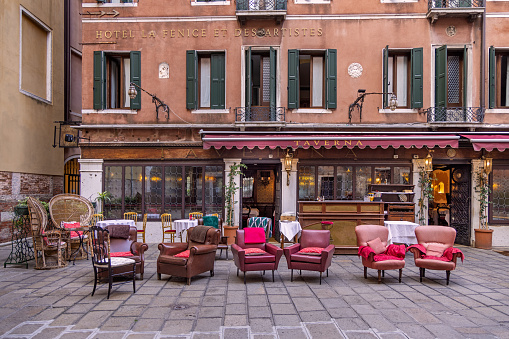 Venice, Italy - October 6th 2022:  Circle of armchairs outside a hotel and restaurant in the center of the old and famous Italian city Venice