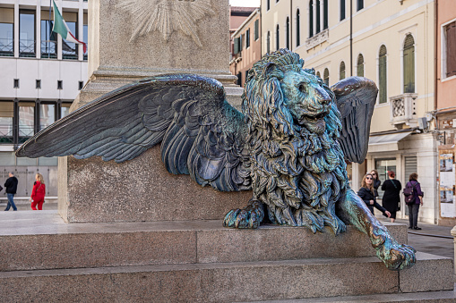 Venice, Italy - October 9th 2022: The Lion of St. Mark is a symbol for Venice and is seen all over. This one is sitting on a public square  in the center of the old and famous Italian city