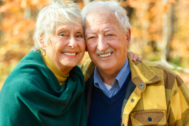 istock Beautiful Elderly couple embracing in autumn park 1438940040