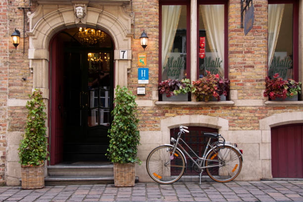 bruges, belgio. bicicletta d'epoca fermata davanti alla vecchia facciata del malleberg hotel. - bruges town hall foto e immagini stock