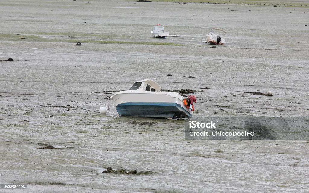 aground boat in the seabed at low tide in the North of France with no people aground boat in the seabed at low tide in the North of France Beach Stock Photo