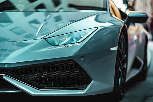Munich, Germany – February 15, 2020: Closeup details of lamborghini sports car in urban street setting. Amazing green and teal color reflecting daylight in the city.