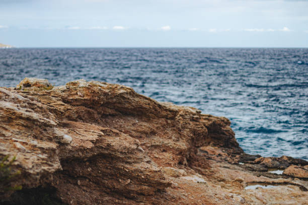 A wide angle shot of a rocky beach surrounded by water