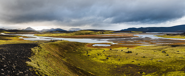 The landscape view of the mountains and fields of the Highland region, Iceland near the water