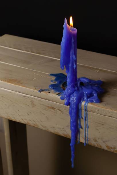 istock blue candle burning and melting on a wooden table 1438964590