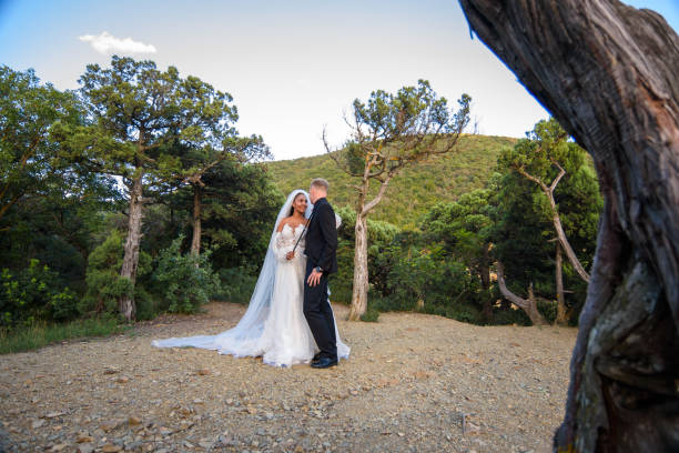 Beautiful interracial wedding couple walking in the old forest
