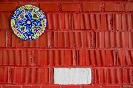 ceramic plate on a red brick wall