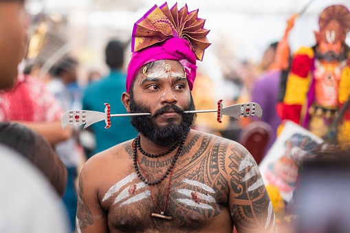 Singapore, Singapore – February 08, 2020: Thaipusam is a religious celebration by devotees. Its highlight is a barefoot walk of devotees carrying milk pots and dancing with prickly kavadis.
