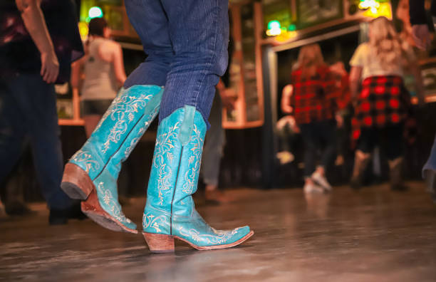 Country dancing boots Las Vegas, United States – January 01, 2020: Las Vegas, Nevada - January 2020: A female wearing turqoise cowboy boots dances at a bar's country-themed night. country and western music stock pictures, royalty-free photos & images