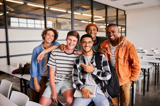 istock Smiling young male college students hanging out in a classroom 1438968805