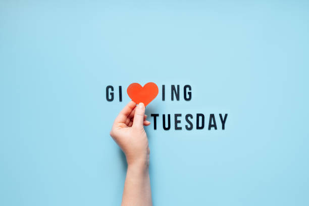 giving tuesday, give, help, donation, support, volunteer concept with red heart in female hands and text giving tuesday on blue background. es hora de dar - giving tuesday fotografías e imágenes de stock
