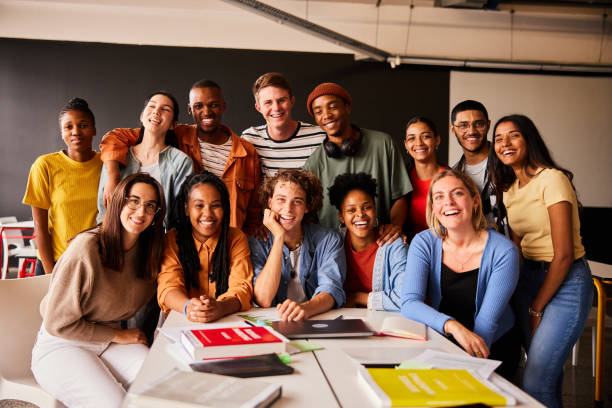 istock Group of smiling young college students hanging out in a classroom 1438969372