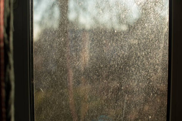 Dust on glass. Dirty window in morning. Surface in fine sand. Window details.