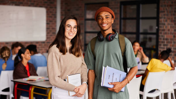 istock Two diverse young college students smiling in a classroom 1438971013
