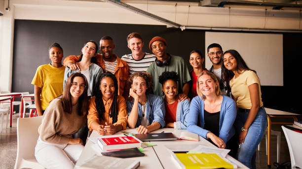 istock Smiling group of young college students hanging out in a classroom 1438971621