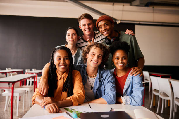 istock Smiling young college students hanging out in class together 1438972022