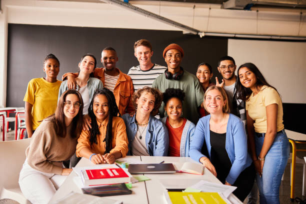 istock Group of smiling young college students hanging out in class together 1438972315