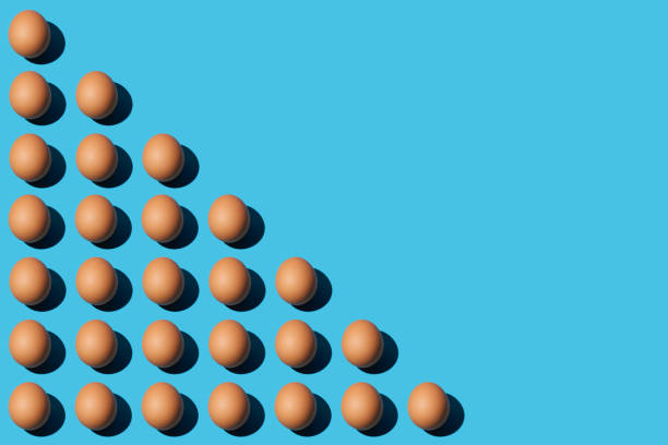 A pattern of brown chicken eggs lying diagonally on the left half of the blue background. Right side for copy space, close-up, top view.
