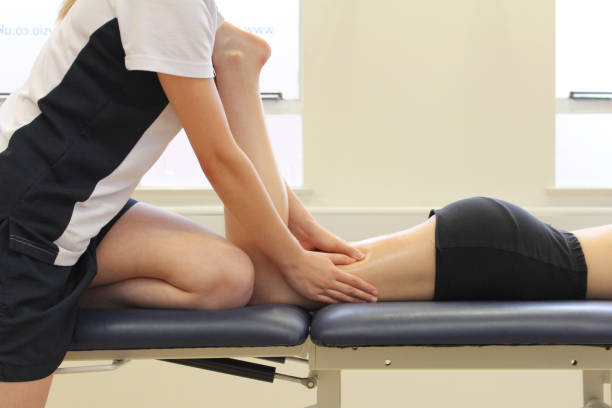 terapeuta de masaje tratando la pierna de un paciente - isquiotibial fotografías e imágenes de stock