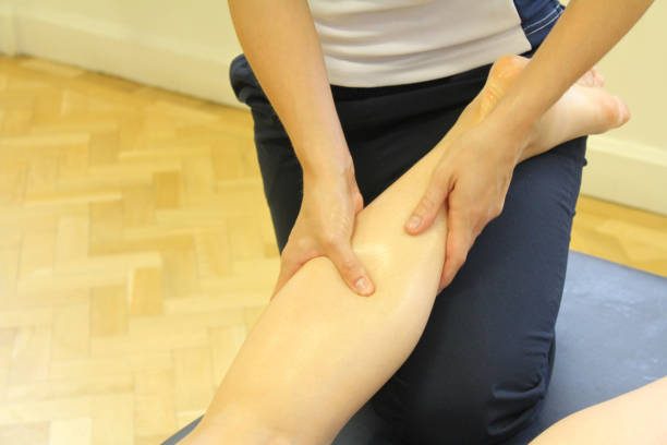 istock Massage therapist treating a patient's calf and lower-leg 1438974448