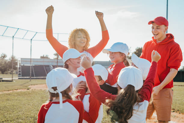 Little league team celebrates winning homerun together with coaches stock photo