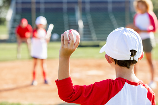 A Young girl play baseball on summer day