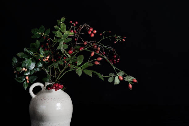 istock Branches of red berries in white vase. 1438977934