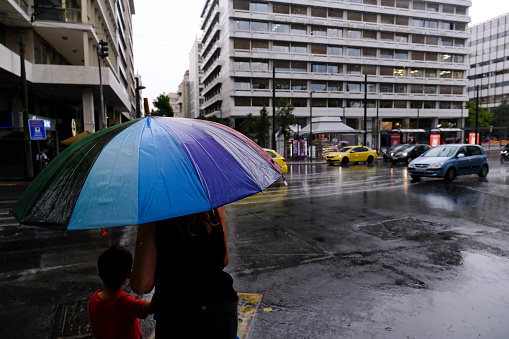 Pedestrians protect themself from the rain with umbrellas during a rainfall in Athens, Greece on August 23, 2022.