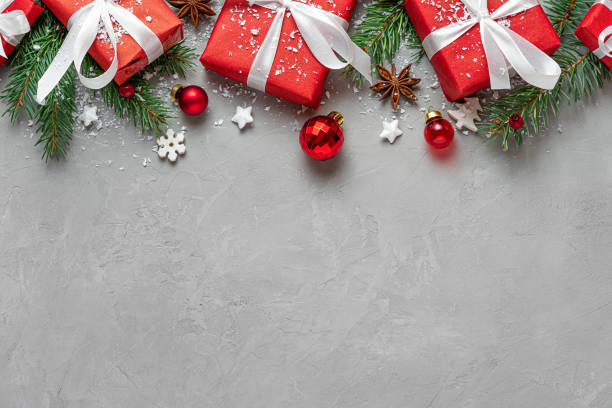 istock Christmas composition. Red gift boxes, fir tree and holiday decorations on gray background. Flat lay. Layout. Top view 1438983645